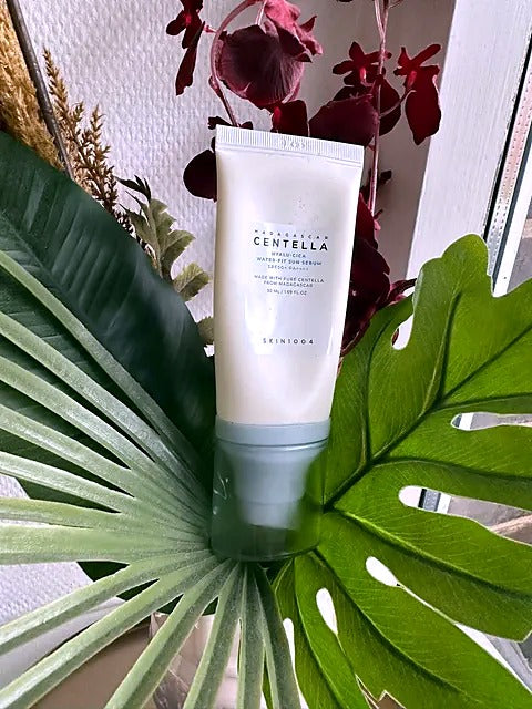SKIN1004 Centella Hyalu-Cica Sun Serum SPF50+ mellem grønne palmeblade